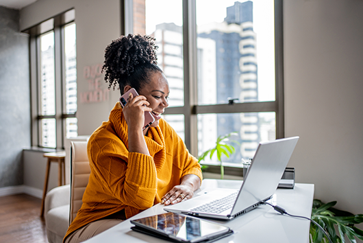 Woman on phone and laptop